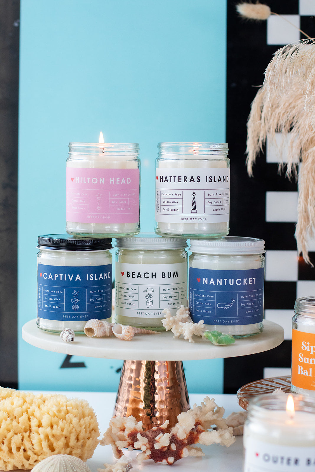Group of coastal candles with surfboard in background.