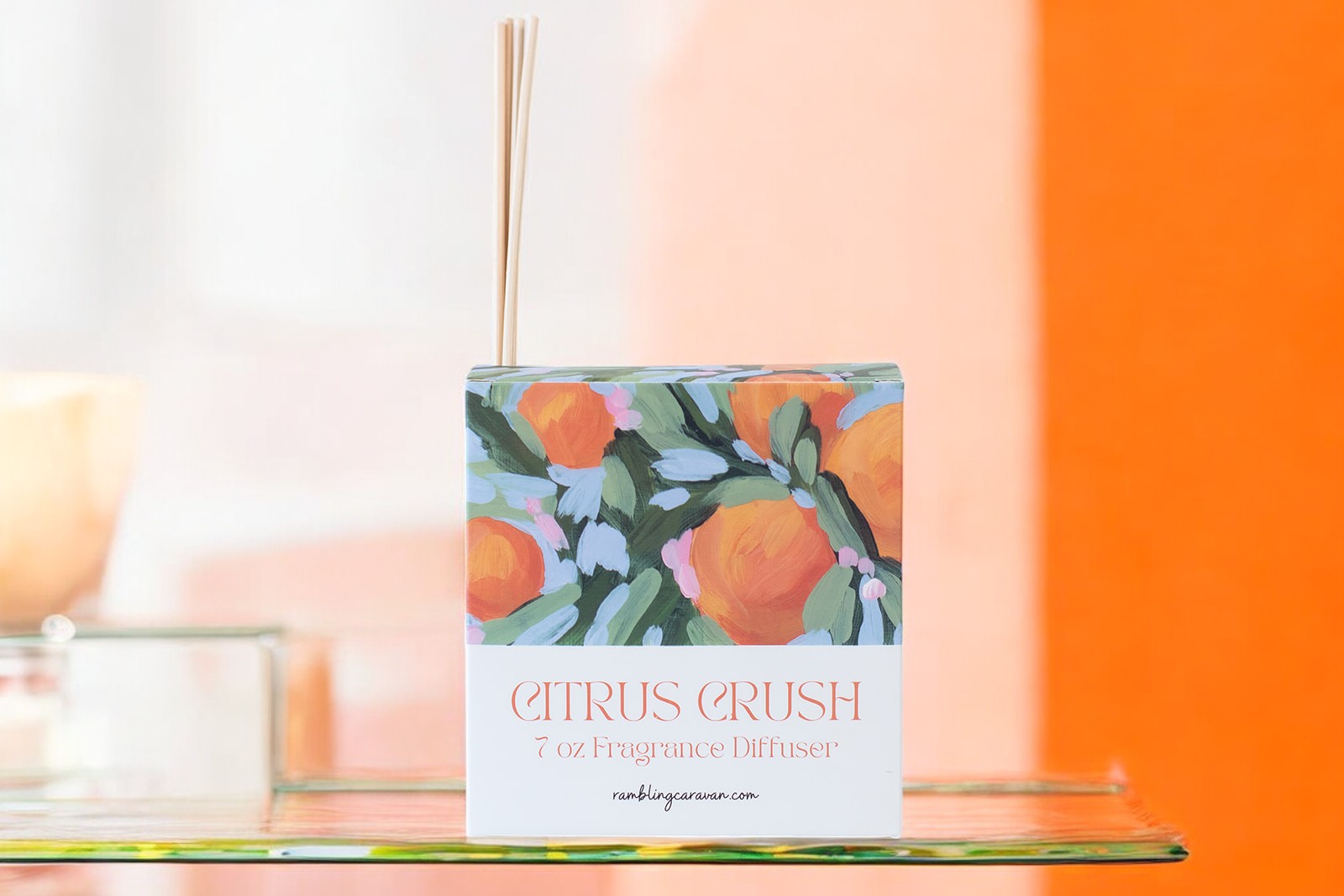 Citrus crush diffuser in kitchen with citrus and flowers in background.