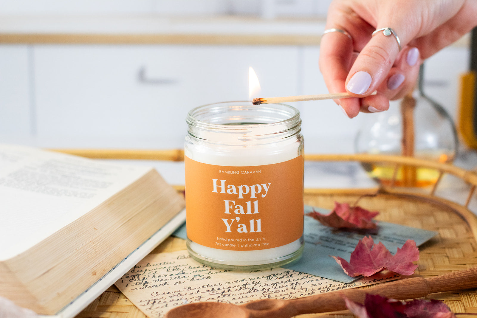 Happy Fall Y'all Candle being lit with a match in kitchen.