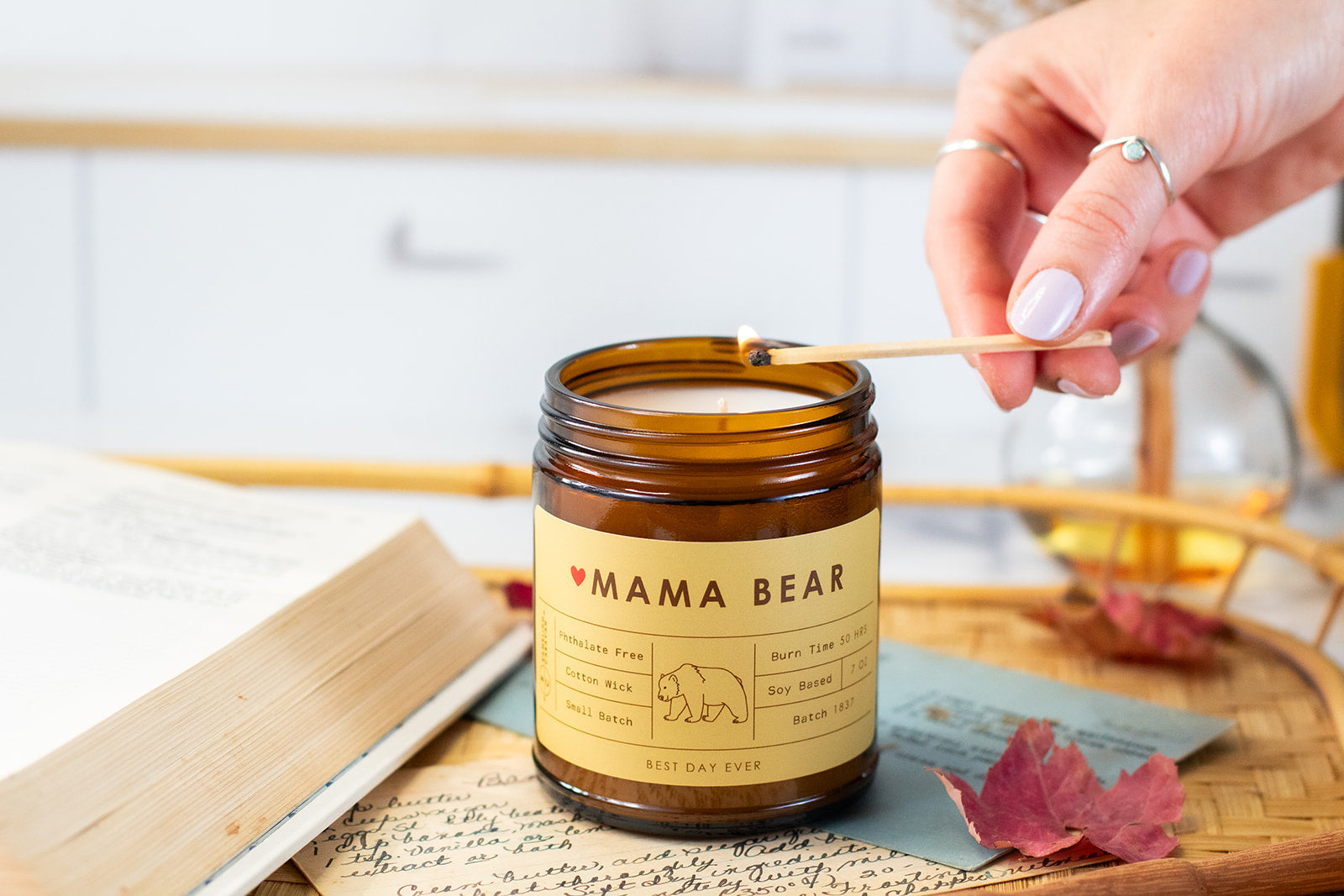 Mama bear candle being lit by woman in a kitchen.
