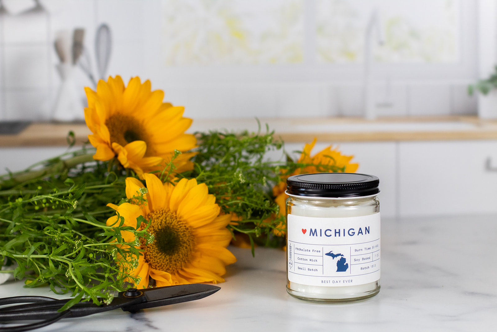 Home state Michigan candle with sunflowers in a ktichen.