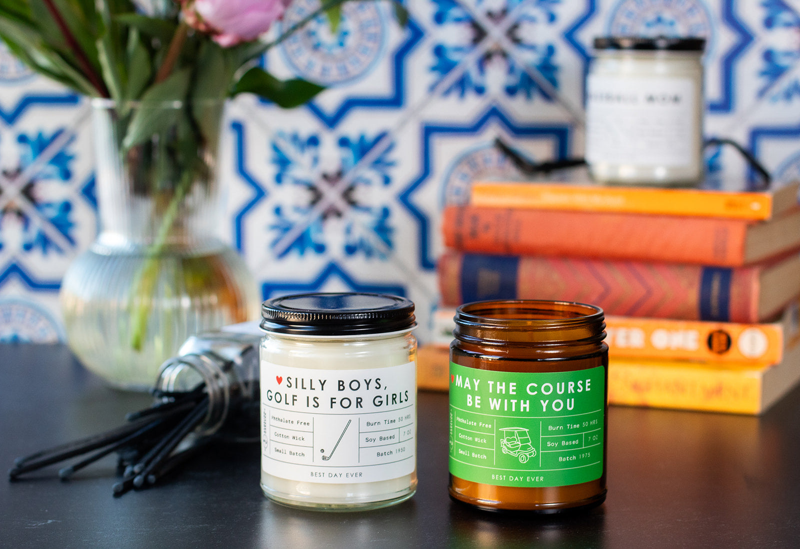 Hobby candles with books and flowers in background.
