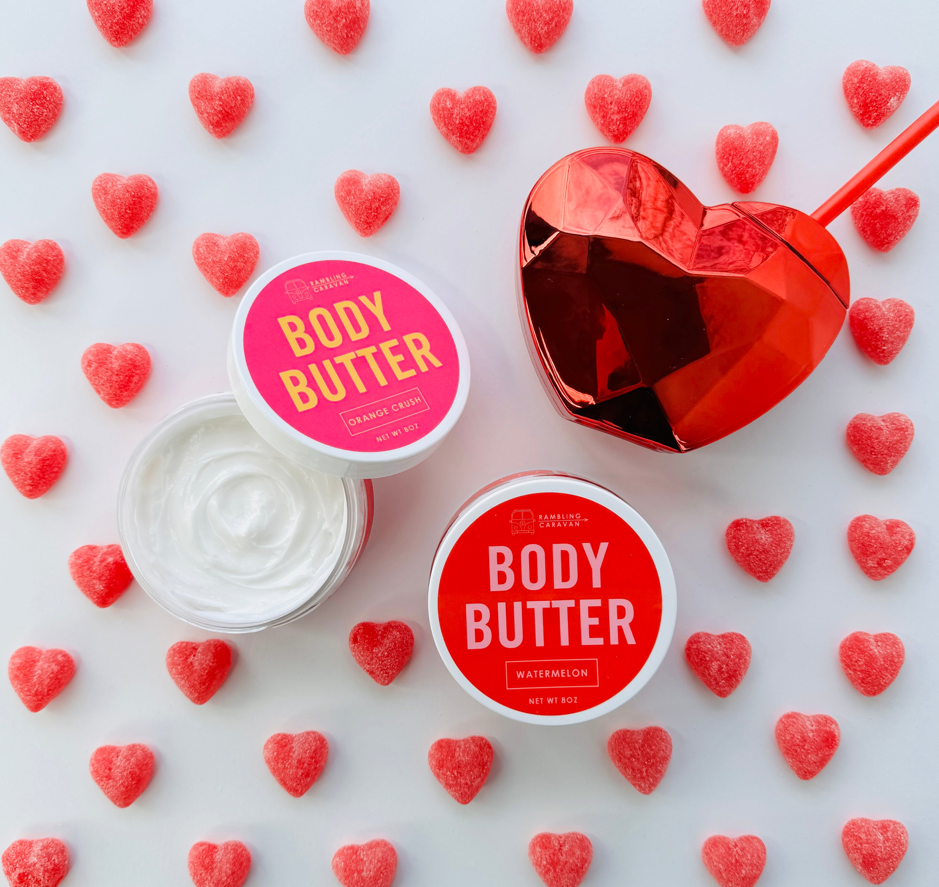 Watermelon and orange crush body butter surrounded by candy hearts.